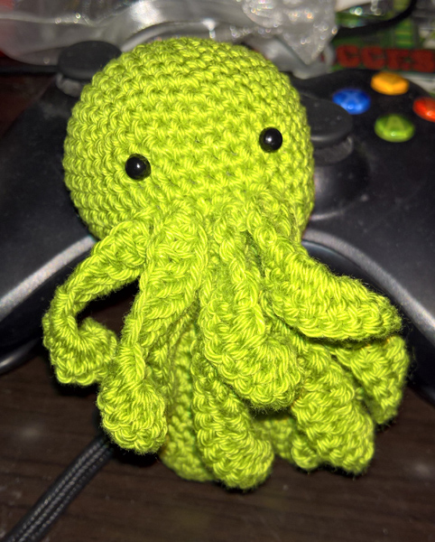 Ein gehäkelter Cthulug Amigurumi dem noch die Arme fehlen.
